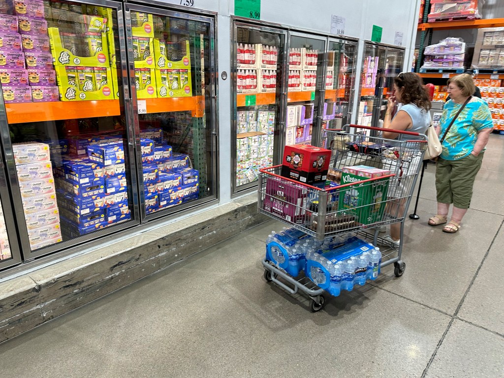 Shoppers evaluate products in refrigerators at a Costco warehouse in Parker, Colorado on August 22, 2024.